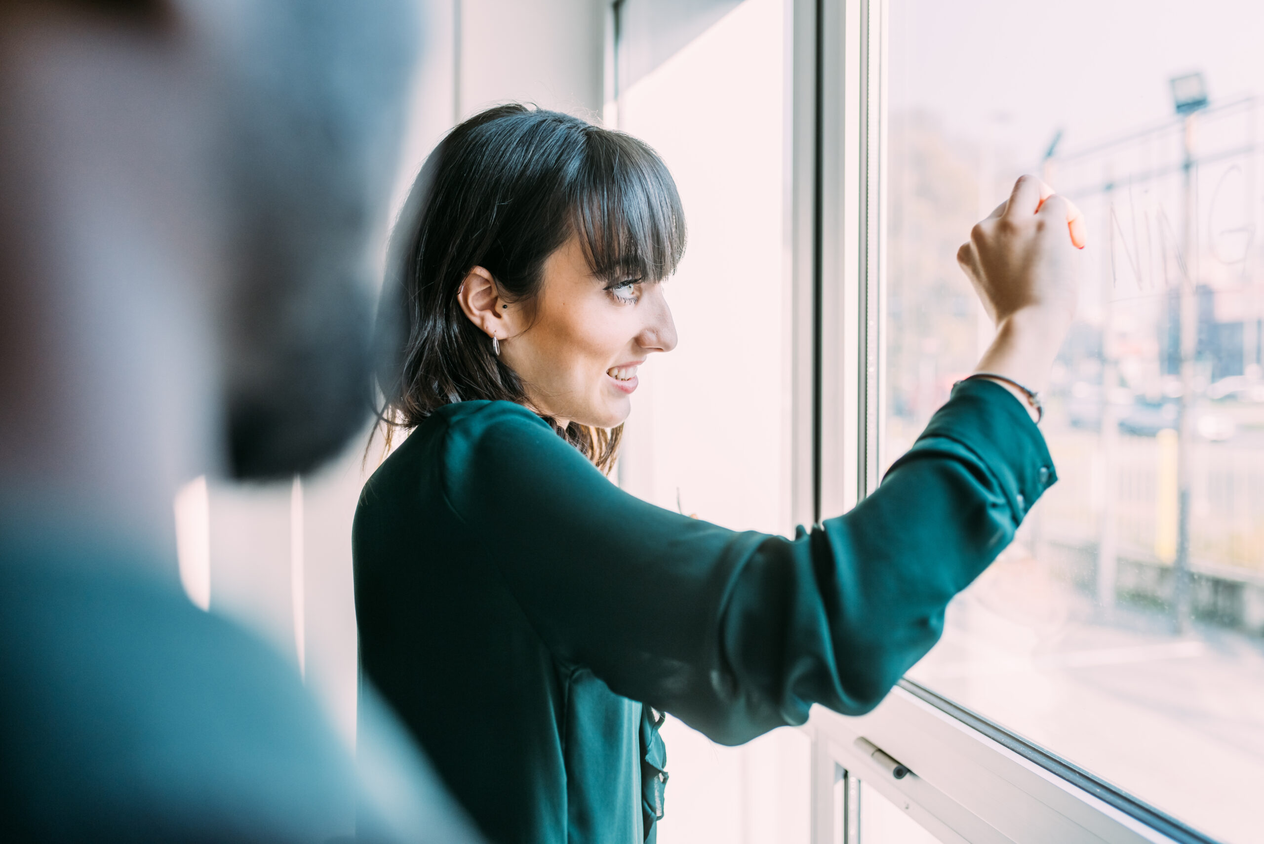 business people having a meeting writing on a glass window