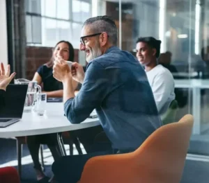 man in meeting drinking from mug